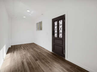 Step into this inviting space featuring a stunning dark wood door and matching flooring, creating a warm and elegant atmosphere.