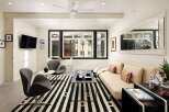 This modern living room boasts a sleek design with a striking black and white striped rug, creating a bold statement.