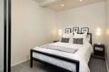This modern bedroom offers a serene retreat with its minimalist design and neutral color palette.