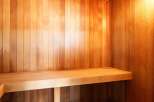 Step into relaxation with this stunning sauna, featuring beautiful wooden paneling and a comfortable bench.