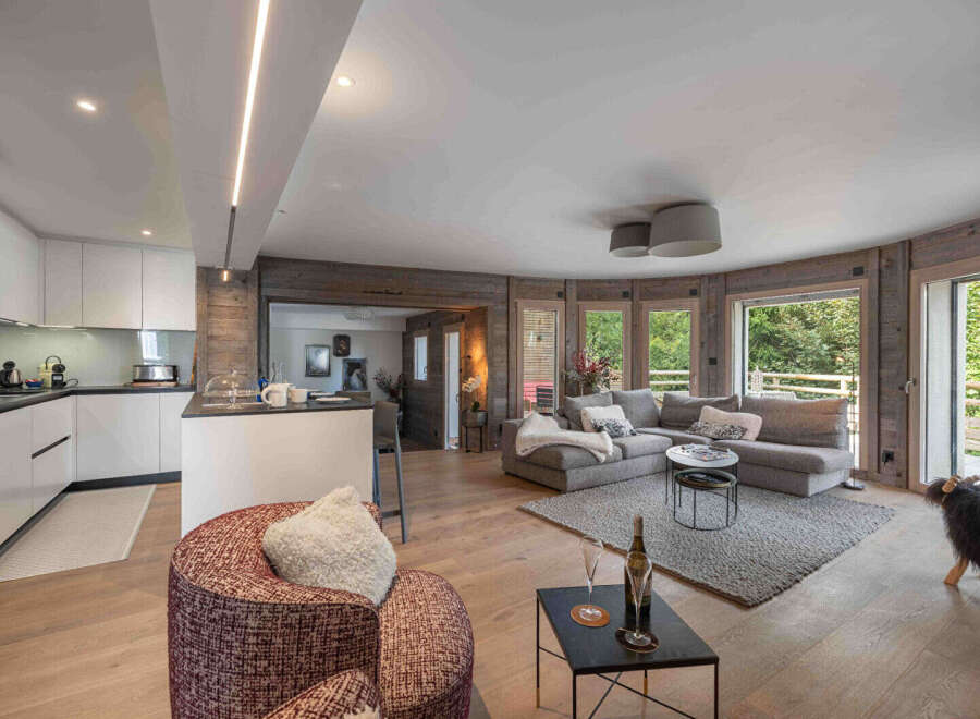 Experience luxury living in this stunning property, featuring a modern kitchen and a cozy living area with a comfortable sectional sofa.