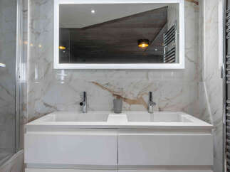 This luxurious bathroom features a modern double vanity with sleek chrome fixtures.