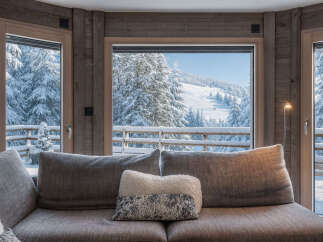 Experience the ultimate winter escape in this stunning property! Enjoy breathtaking views of snow-covered mountains and lush forests from the comfort of your cozy living room.