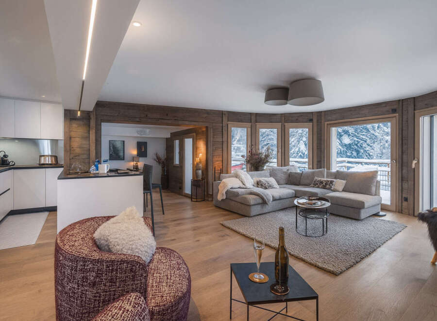 Experience luxury living in this stunning property, featuring a modern kitchen and a cozy living area with a plush sectional sofa.