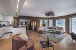 Experience luxury living in this stunning property, featuring a modern kitchen and a cozy living area with a plush sectional sofa.