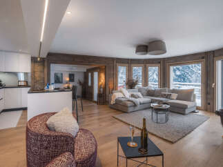 Experience luxury living in this stunning property, featuring a modern kitchen and a cozy living area with a plush sectional sofa.
