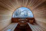 Experience ultimate relaxation in this stunning sauna with breathtaking views of a snow-covered landscape.