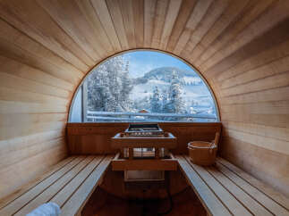 Experience ultimate relaxation in this stunning sauna with breathtaking views of a snow-covered landscape.