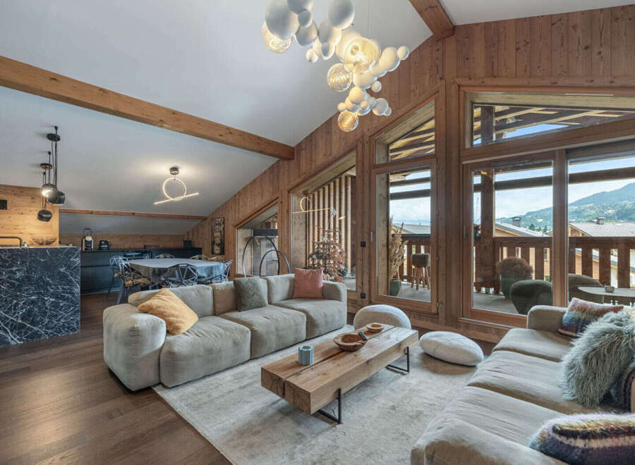 Experience luxury living in this stunning property, featuring a spacious living area with a cozy sectional sofa and a modern coffee table.