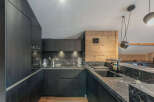 This stunning kitchen boasts a modern design with sleek black cabinetry and luxurious marble countertops.