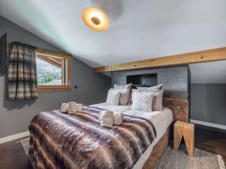 Experience the epitome of comfort in this stunning bedroom, featuring a cozy bed adorned with a luxurious faux fur blanket.