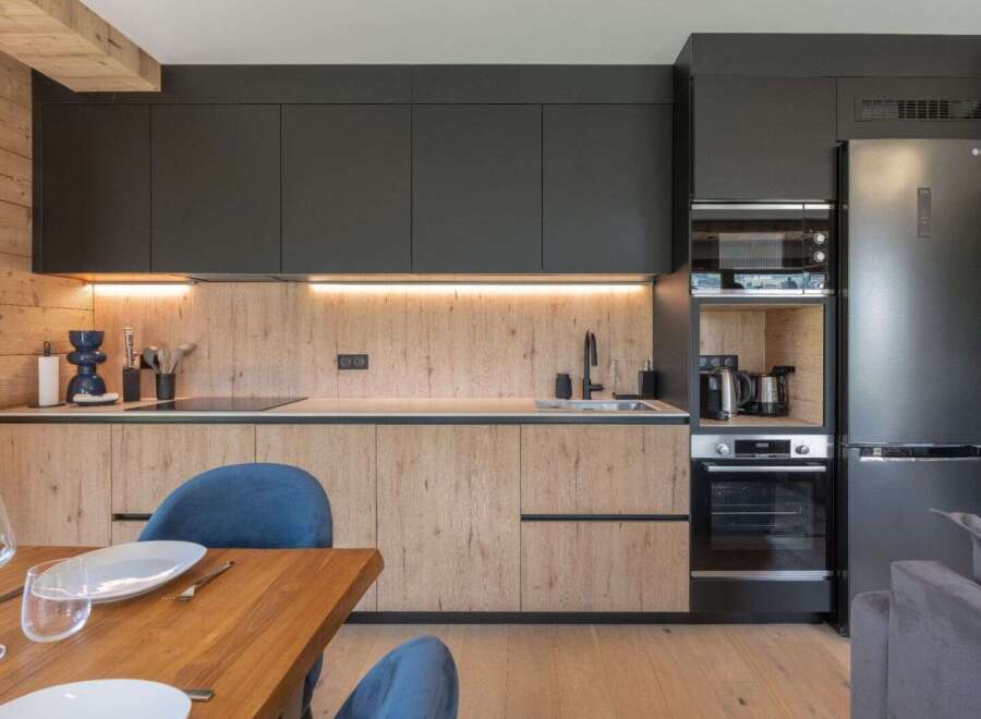 This modern kitchen boasts sleek black cabinetry and warm wood accents, creating a stylish and inviting space.