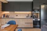 This modern kitchen boasts sleek black cabinetry and warm wood accents, creating a stylish and inviting space.