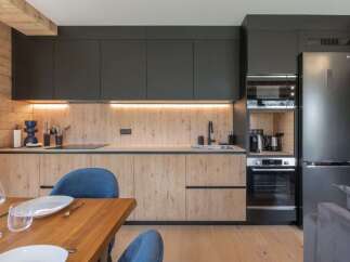 This modern kitchen boasts sleek black cabinetry and warm wood accents, creating a stylish and inviting space.