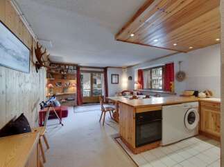 This charming property features a cozy living space with wooden accents, creating a warm and inviting atmosphere.