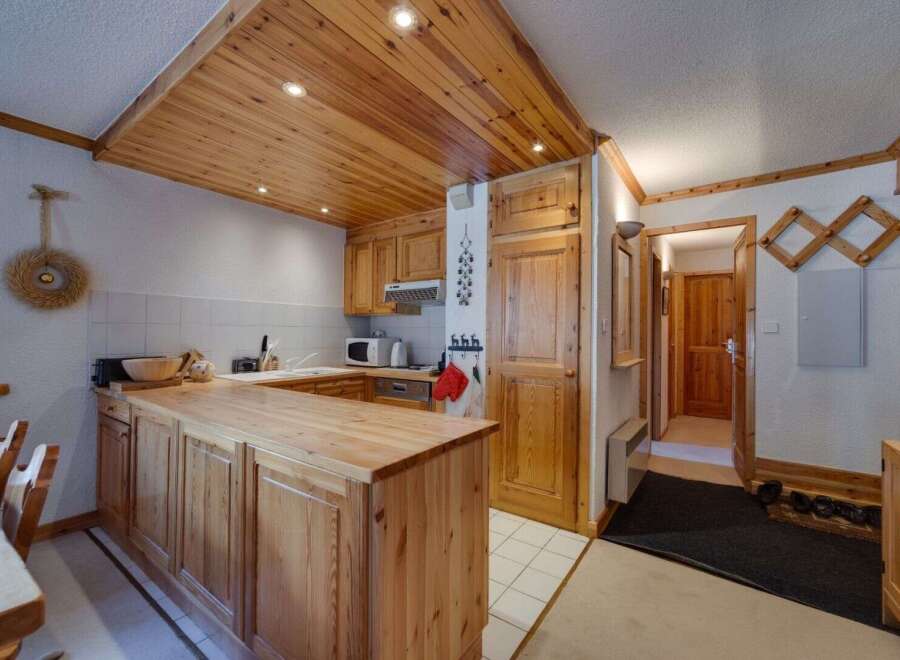 This charming kitchen features a warm, inviting atmosphere with its wooden cabinetry and ceiling.