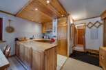 This charming kitchen features a warm, inviting atmosphere with its wooden cabinetry and ceiling.
