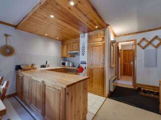 This charming kitchen features a warm, inviting atmosphere with its wooden cabinetry and ceiling.