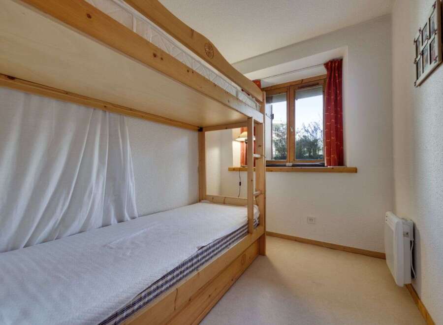 This cozy bedroom features a charming wooden bunk bed, perfect for accommodating guests or family members.