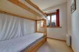 This cozy bedroom features a charming wooden bunk bed, perfect for accommodating guests or family members.