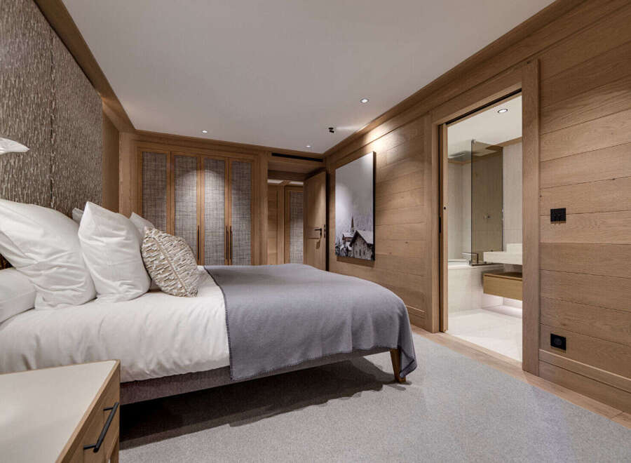 Experience luxury living in this stunning bedroom, featuring exquisite wooden paneling and a serene ambiance.