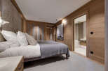 Experience luxury living in this stunning bedroom, featuring exquisite wooden paneling and a serene ambiance.