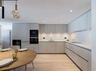 This modern kitchen boasts sleek, minimalist design with ample storage and a functional layout.