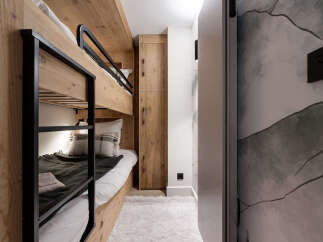 This cozy bedroom features custom-built bunk beds with a rustic wooden design, perfect for a family or group.