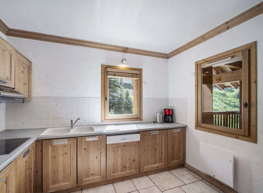 Discover the charm of this inviting kitchen, featuring warm wooden cabinetry and a bright, airy atmosphere.