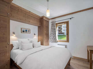 This cozy bedroom features a comfortable bed with crisp white linens, perfect for a relaxing stay.