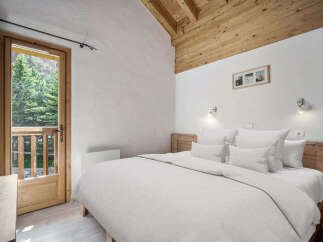 This cozy bedroom features a comfortable bed with crisp white linens, perfect for a relaxing retreat.