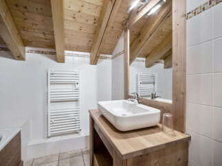 This charming bathroom features a rustic design with wooden beams and a stylish sink.