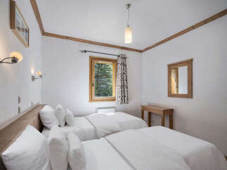 This cozy bedroom features two twin beds with crisp white linens, perfect for a comfortable stay.