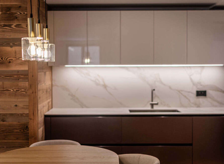 This modern kitchen boasts a sleek design with a combination of wood and marble elements.