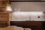 This modern kitchen boasts a sleek design with a combination of wood and marble elements.