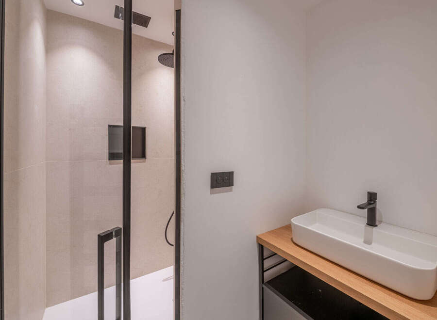 Step into a modern bathroom oasis! This stunning space features a sleek, minimalist design with a walk-in shower and a stylish sink area.
