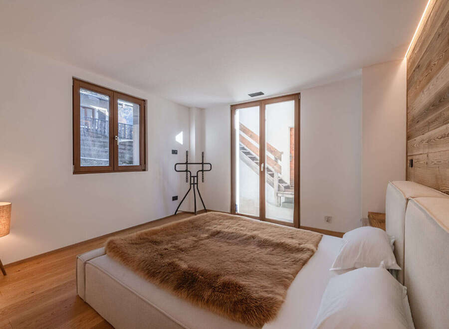 Experience luxury in this stunning bedroom featuring a cozy fur blanket and a modern bed frame.