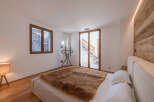 Experience luxury in this stunning bedroom featuring a cozy fur blanket and a modern bed frame.