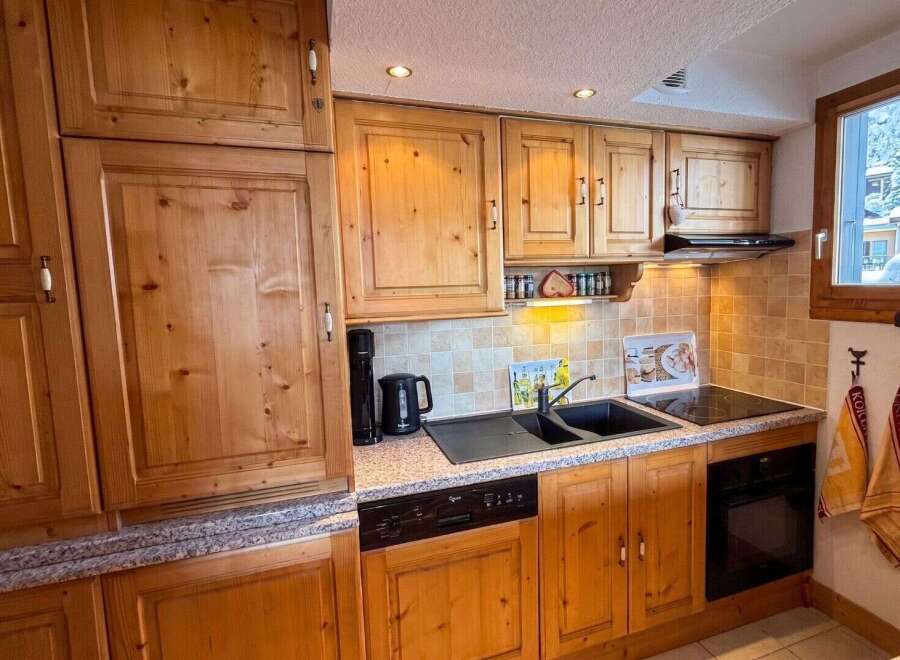 This charming kitchen boasts beautiful wooden cabinetry and a functional layout, perfect for preparing meals.