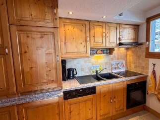 This charming kitchen boasts beautiful wooden cabinetry and a functional layout, perfect for preparing meals.