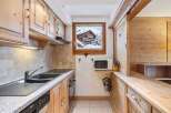 This charming kitchen features warm wooden cabinetry and a granite countertop, creating a cozy and inviting atmosphere.