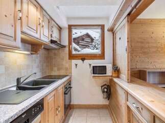 This charming kitchen features warm wooden cabinetry and a granite countertop, creating a cozy and inviting atmosphere.