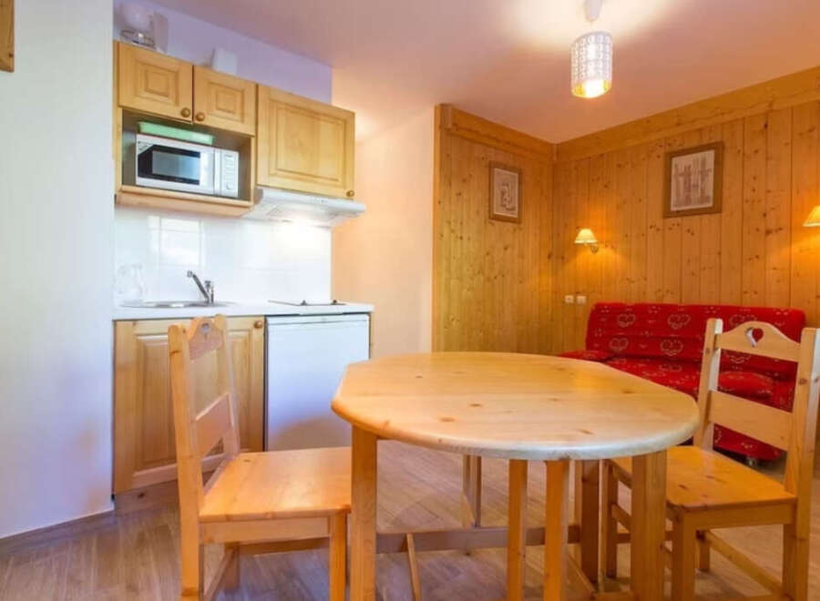 This charming apartment features a cozy living space with a well-equipped kitchenette, perfect for preparing meals.