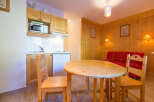 This charming apartment features a cozy living space with a well-equipped kitchenette, perfect for preparing meals.
