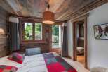 Experience the charm of this cozy bedroom, featuring rustic wooden accents and a warm, inviting atmosphere.