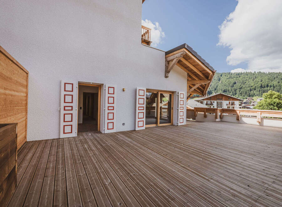Experience the charm of this stunning property featuring a spacious wooden deck, perfect for outdoor gatherings.