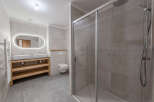 Step into this modern bathroom, featuring a sleek glass shower enclosure and stylish tiled walls.