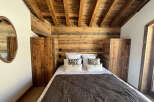 Experience rustic charm in this cozy bedroom featuring a stunning wooden ceiling and headboard.
