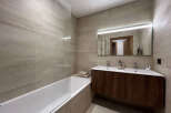 This modern bathroom features a sleek design with a spacious bathtub and a stylish vanity.