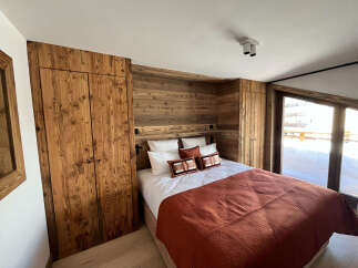 Discover the charm of this cozy bedroom, featuring stunning wooden paneling that adds warmth and character.